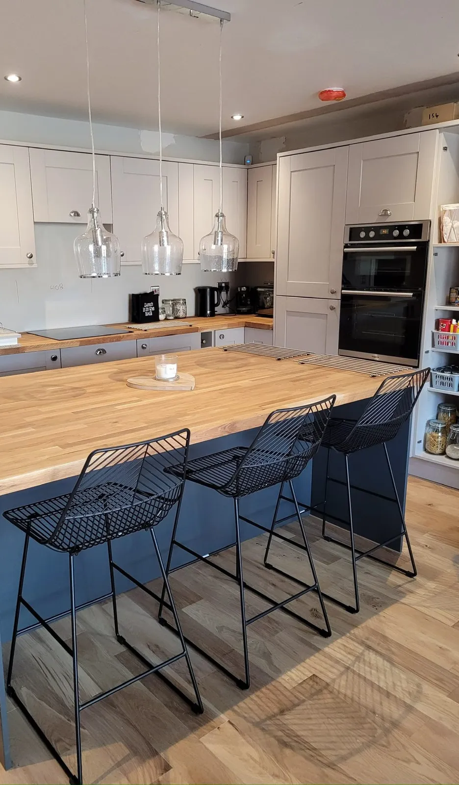 Shaker kitchen with oak-topped island and pendant lights